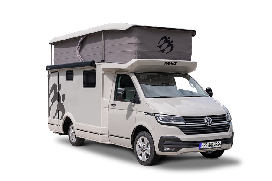 En Knaus Tourer CUVision 500 LT 2024 autocamper med en pop-top tagtelt, set fra siden. Billedet viser køretøjets moderne design i beige med sorte detaljer og et løftet tag, der giver ekstra soveplads. Køretøjet er udstyret med store vinduer og avancerede funktioner, hvilket gør den ideel til fleksible og komfortable rejser.